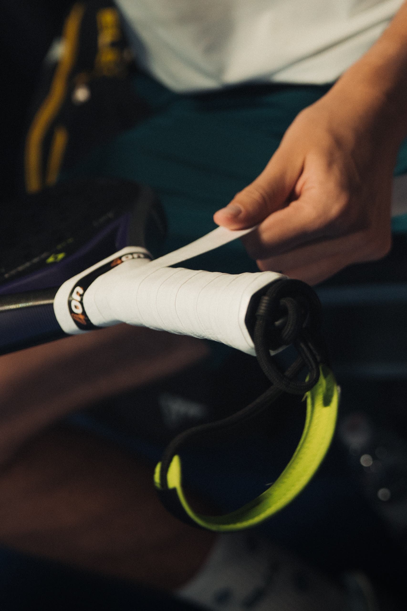 Ruke omotavaju bijeli overgrip oko drške padel reketa